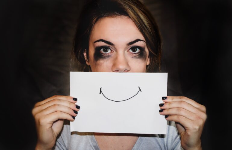 An anxious patient trying to hide her pain behind a fake smile