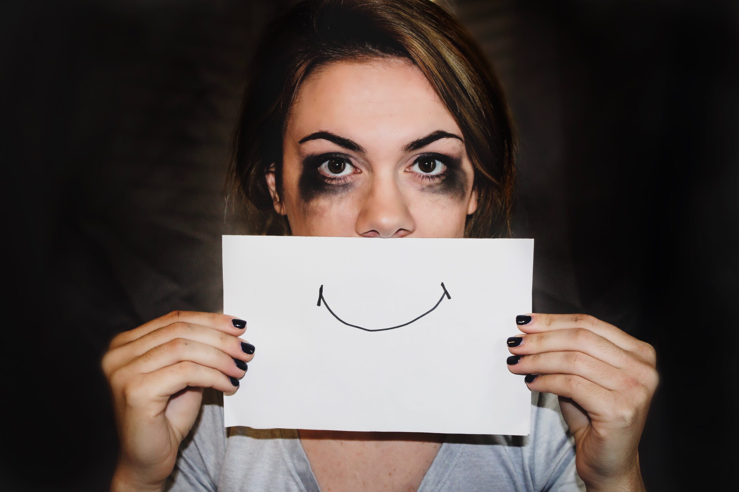 An anxious patient trying to hide her pain behind a fake smile