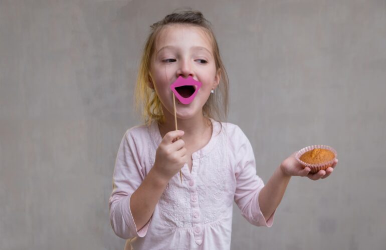 girl eating cupcake fake smile no teeth