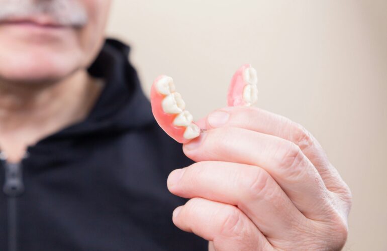 Old man with dentures in his hand