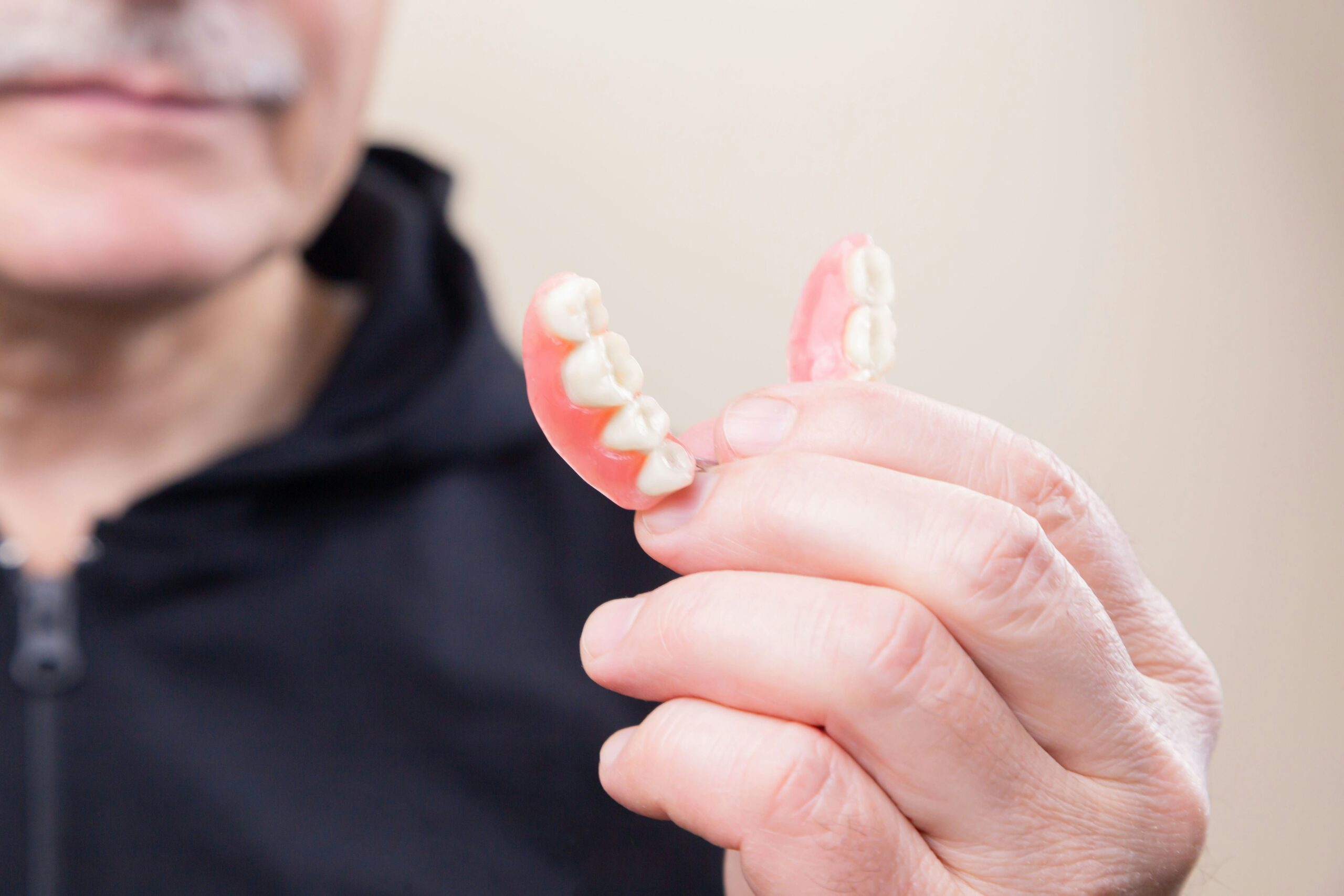 Old man with dentures in his hand